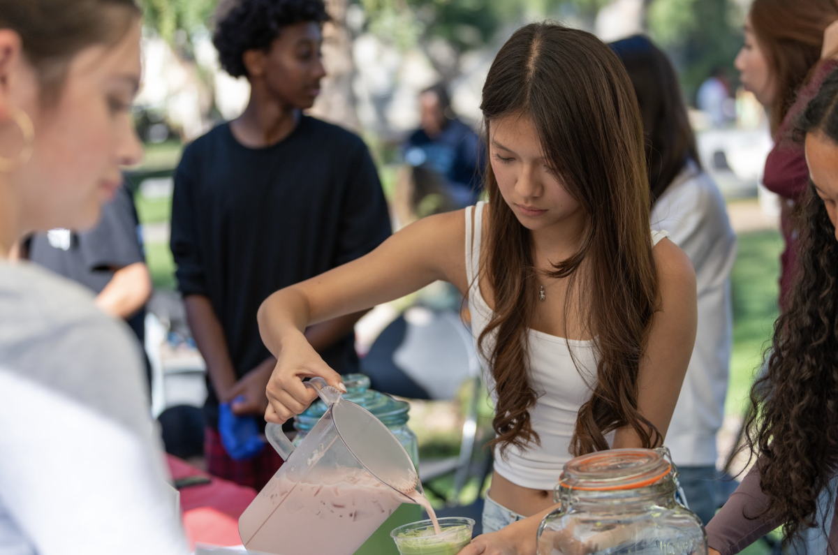 Smiley Zhou pouring a strawberry milk matcha for the Chadwick Marketplace customers